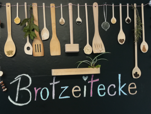 Brotzeitecke Schild mit vielen Holzlöffeln hängend