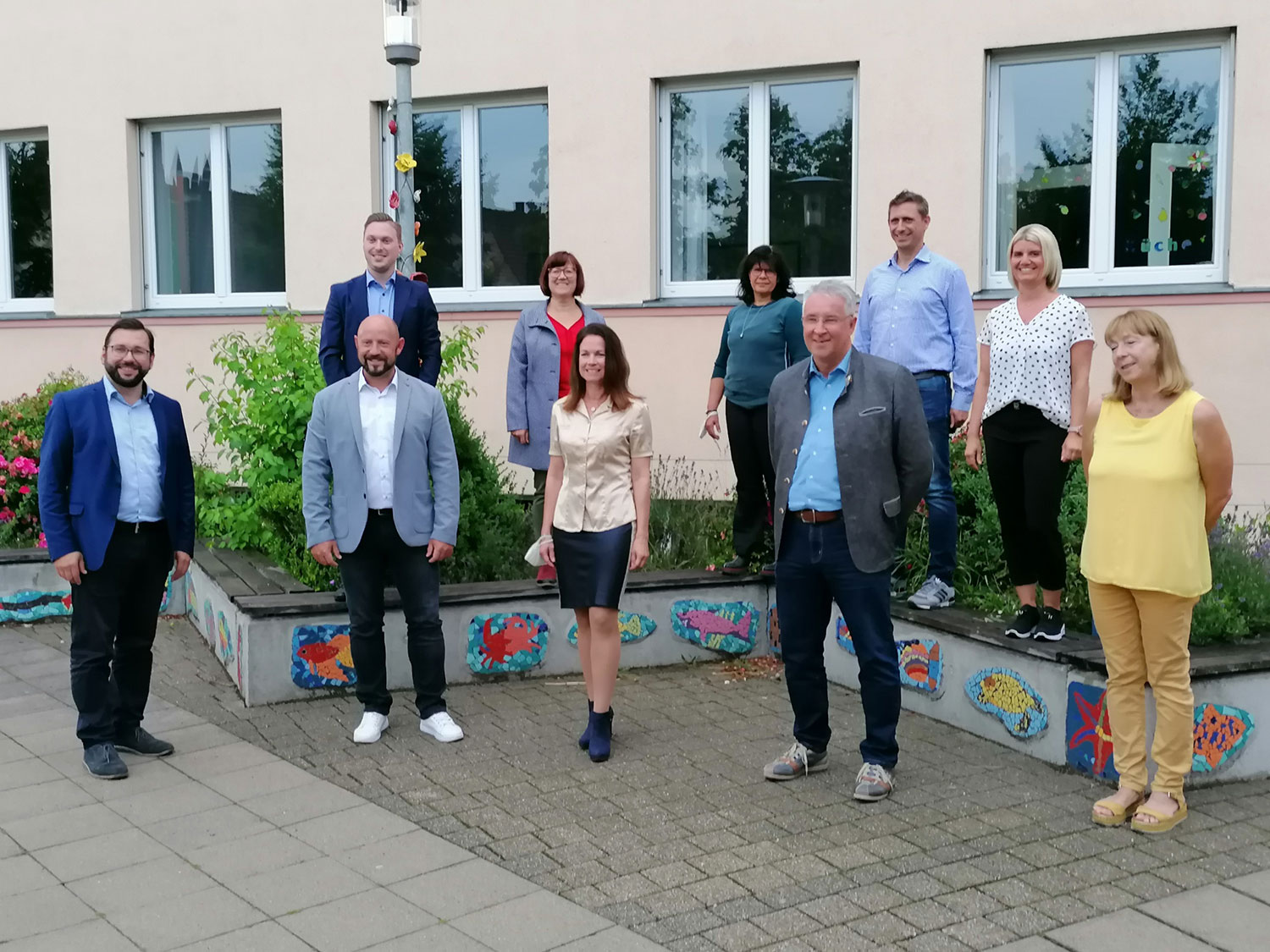 Förderverein Gruppe Männer und Frauen stehen in einem Halbkreis für ein Foto