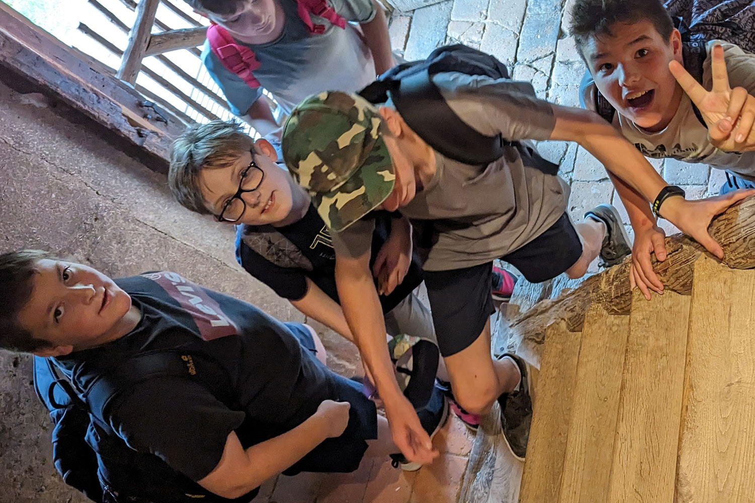 Schüler von oben fotografiert welche eine Holztreppe hinaufsteigen