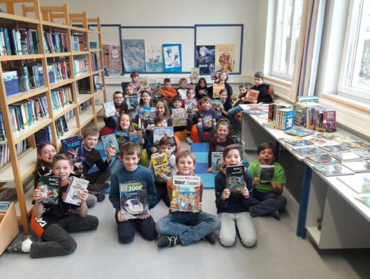 Schülerinnen und Schüler zeigen die neuen Bücher